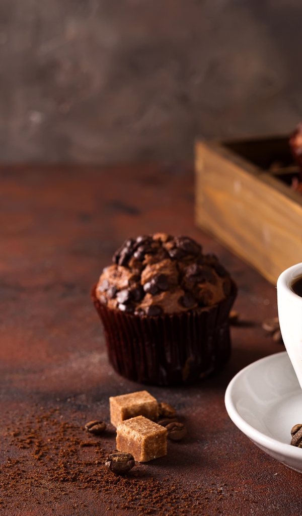 Белая чашка кофе и кекс с шоколадом на столе