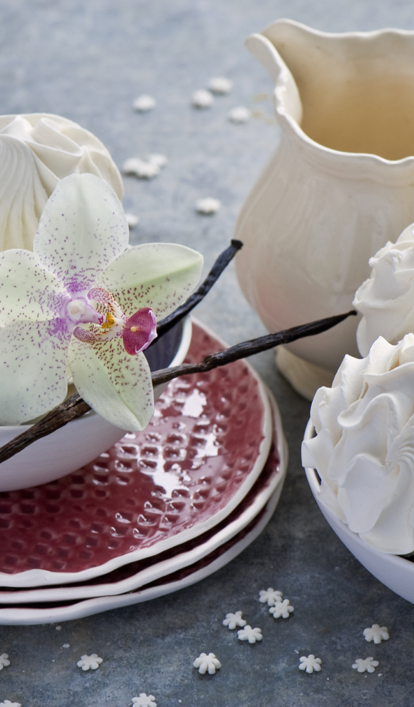 Белый зефир на столе с цветком орхидеи