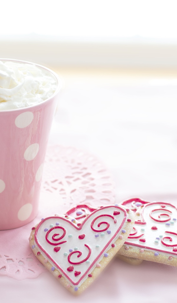 Чашка напитка со взбитыми сливками с печеньем на столе