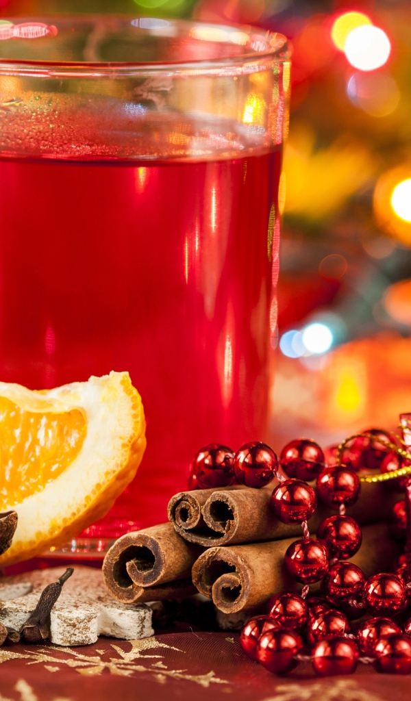 Чашка горячего чая на столе с корицей, бадьяном и кусочком апельсина 