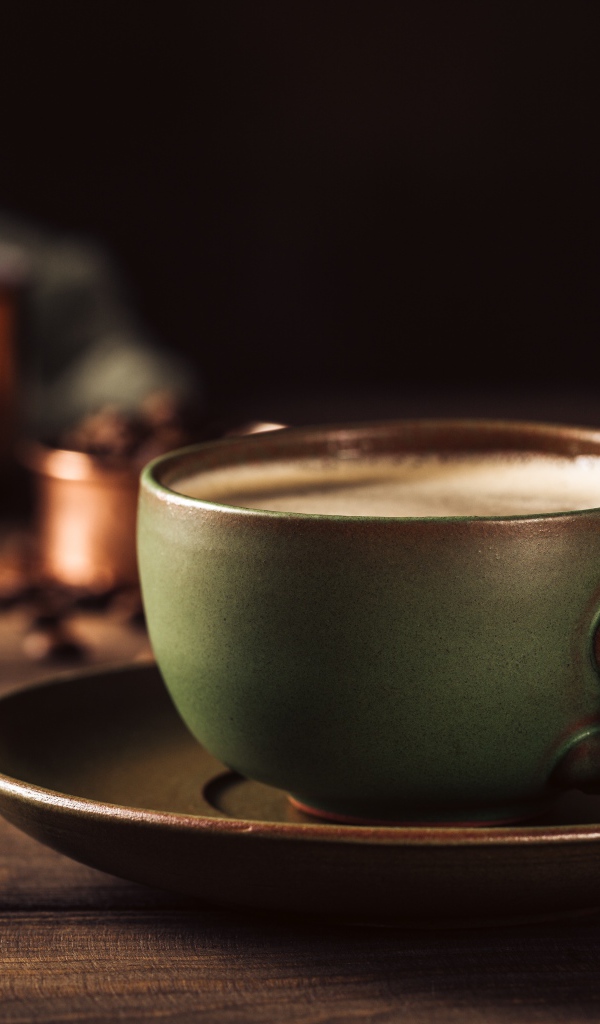 Большая чашка кофе на столе с кофейными зернами 