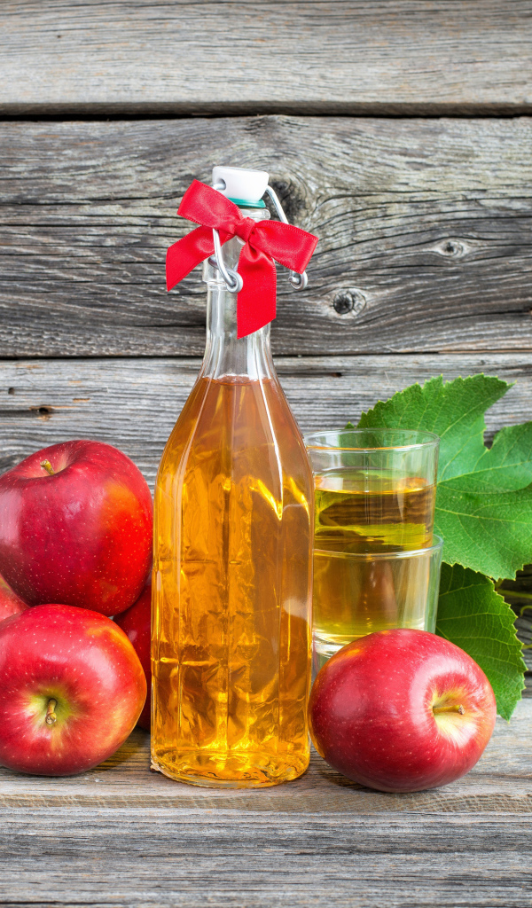 Яблочный сок на столе с красными яблоками