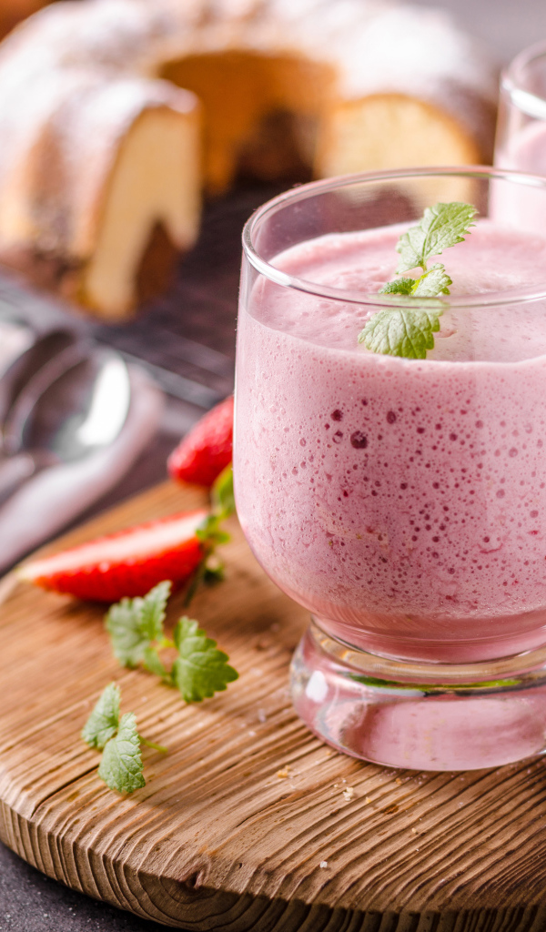 Ягодное смузи в стаканах на столе с клубникой