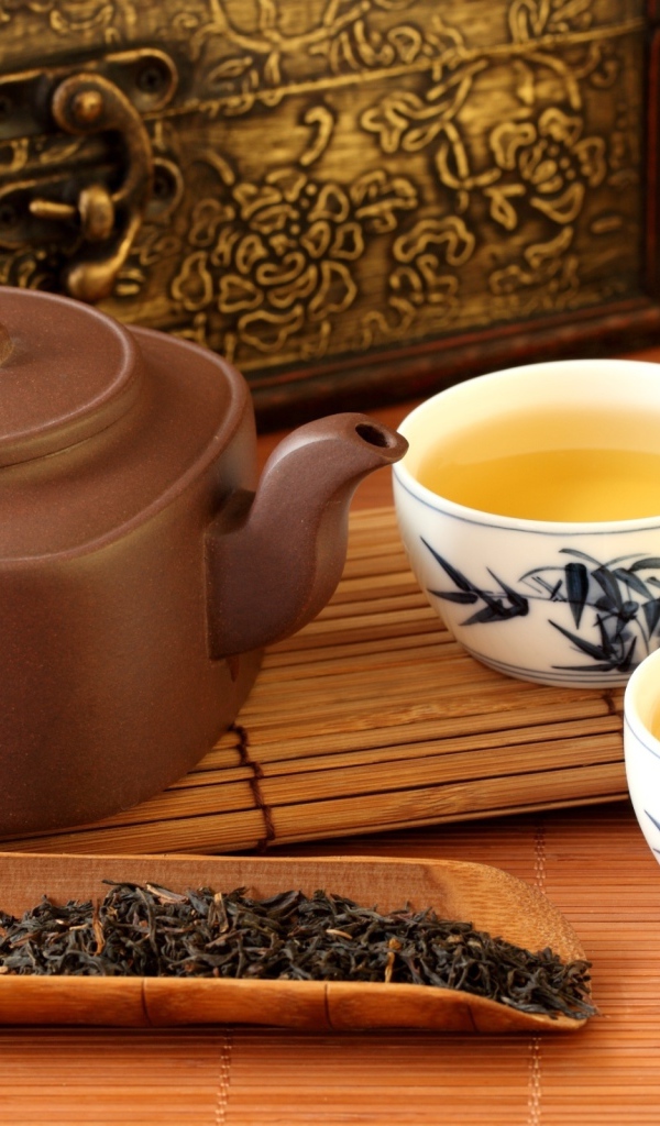 Китайский чайник на столе с чашками