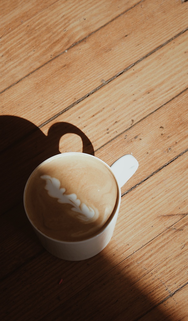 Чашка капучино с рисунком на деревянном столе