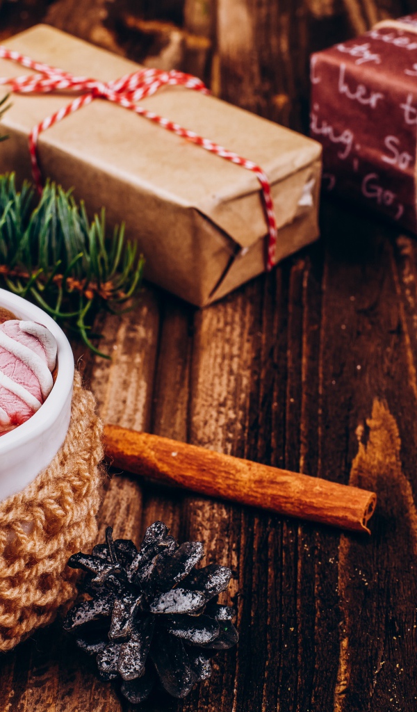 Чашка какао с маршмеллоу на столе с подарками