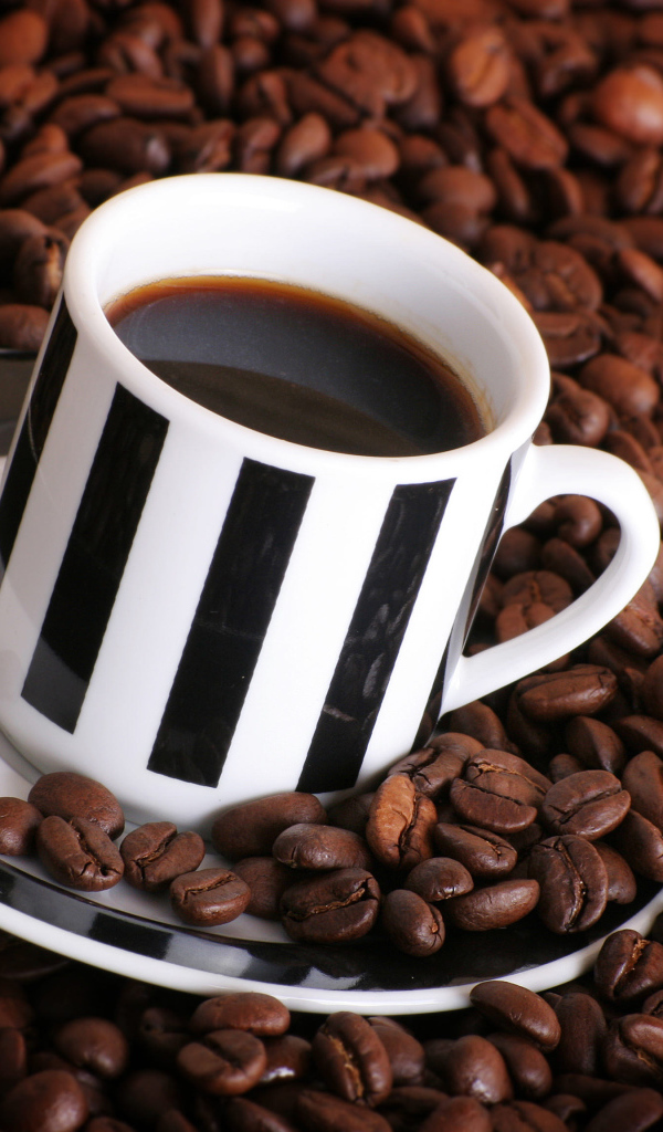 Чашка кофе на столе с кофейными зернами