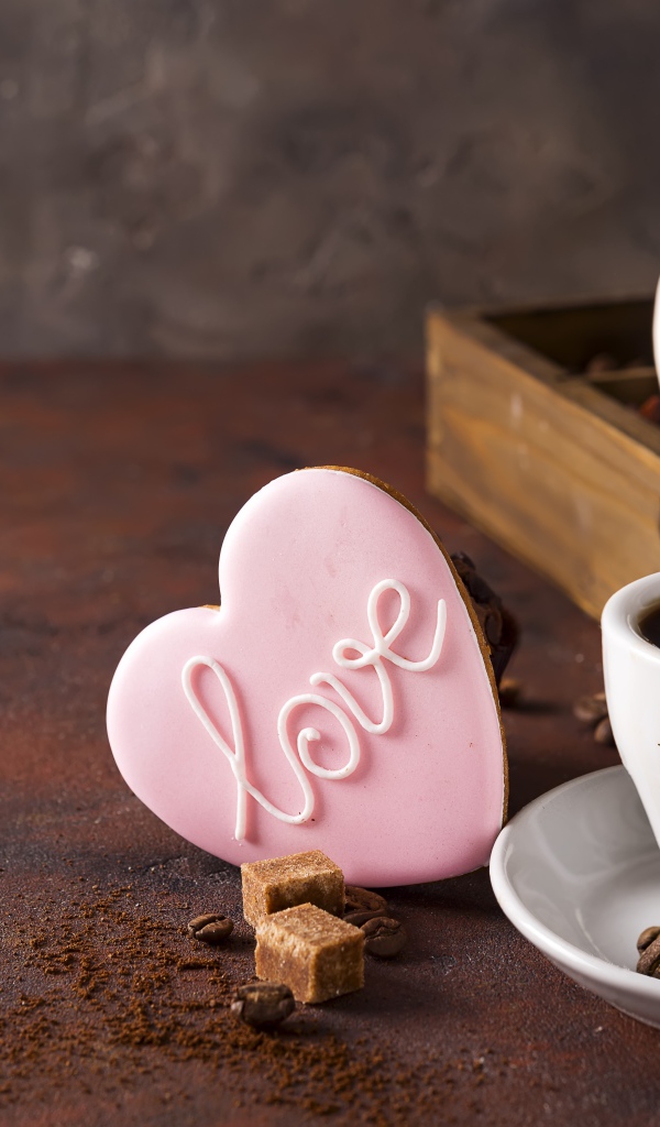 Чашка кофе на столе с сахаром и печеньем в форме сердца 