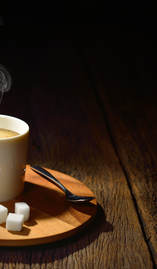 Чашка горячего кофе на столе с сахаром