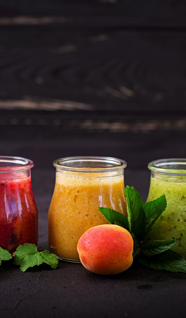 Фруктовое смузи в баночках на столе 