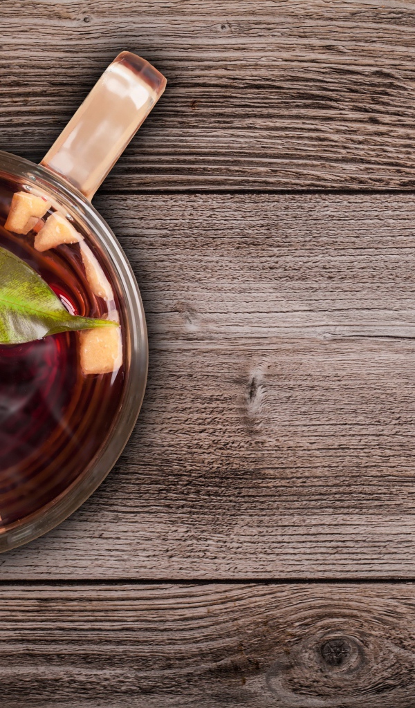 Стеклянная чашка горячего чая на деревянном столе