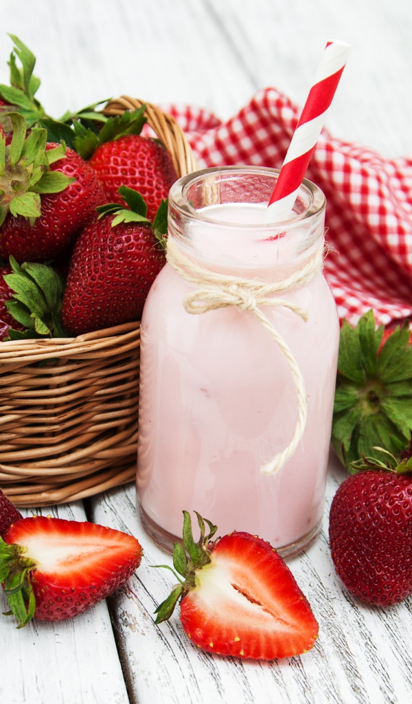 Банка с коктейлем на столе с ягодами клубники