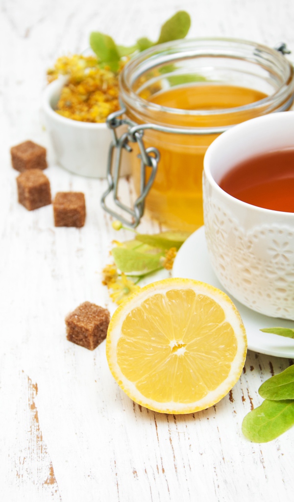 Липовый чай на столе с медом, лимоном, и сахаром
