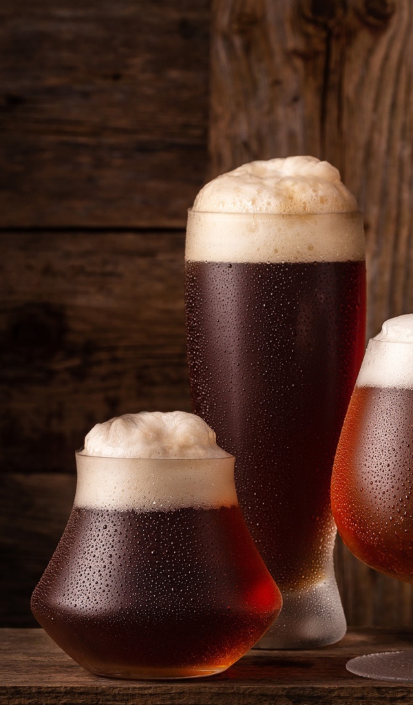 Много бокалов холодного пенного пива на столе 