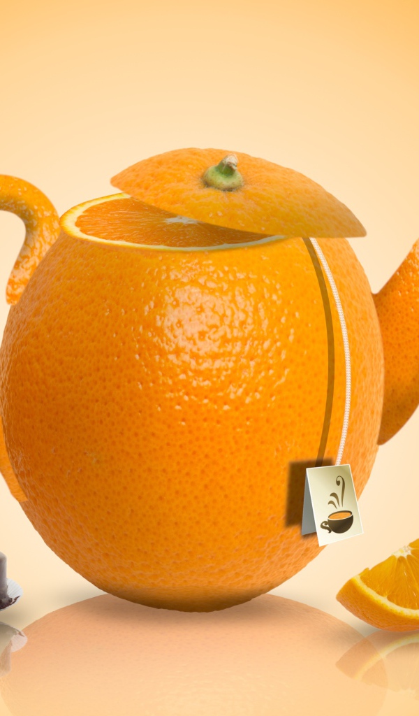 Чайник апельсин на оранжевом фоне с конфетами