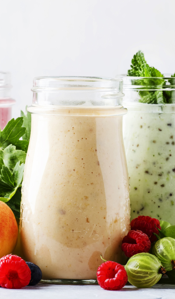 Банки со смузи на столе с ягодами 