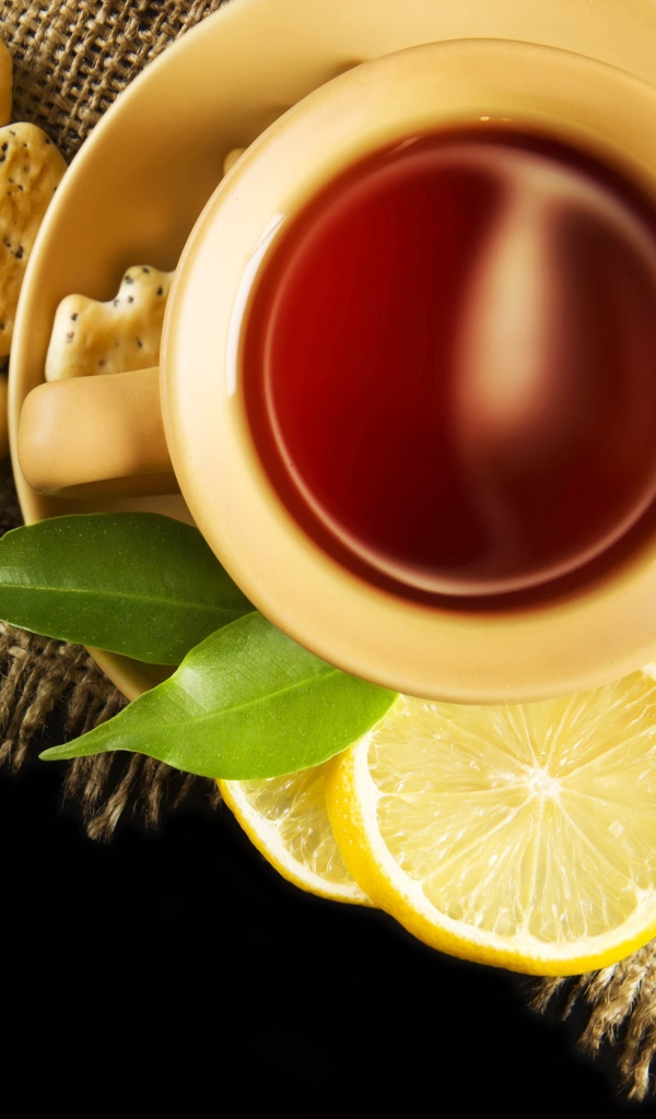 Чай на столе с печеньем и кусочками лимона