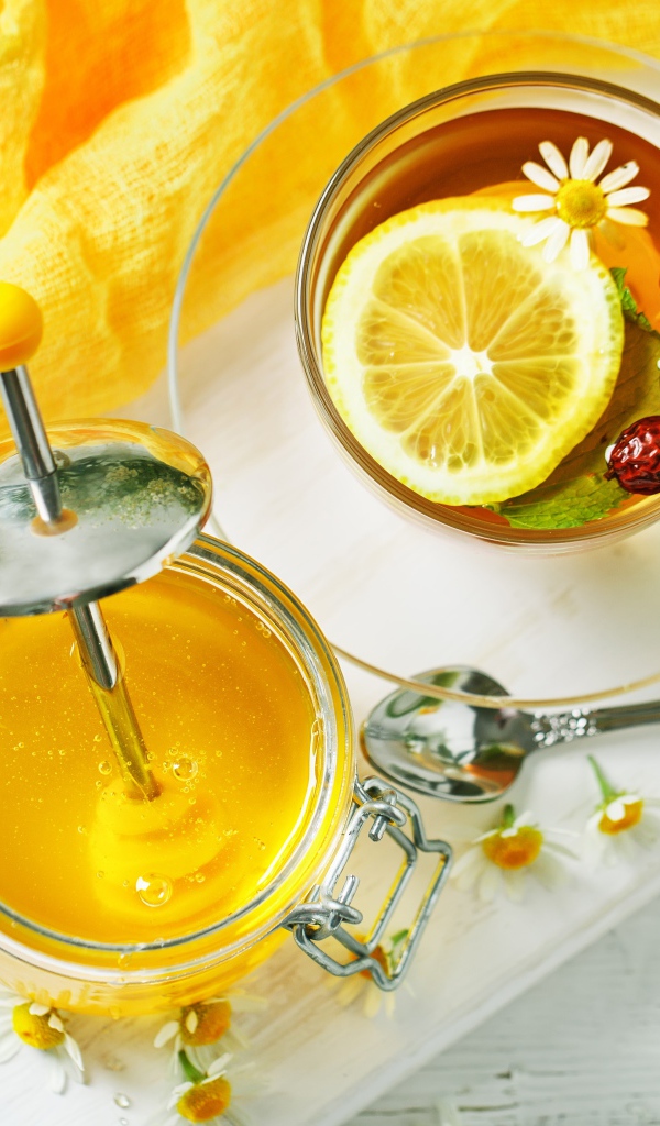 Чай с лимоном и шиповником на столе с медом