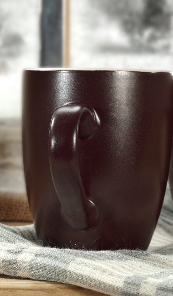 Две коричневые чашки кофе на столе с шарфом