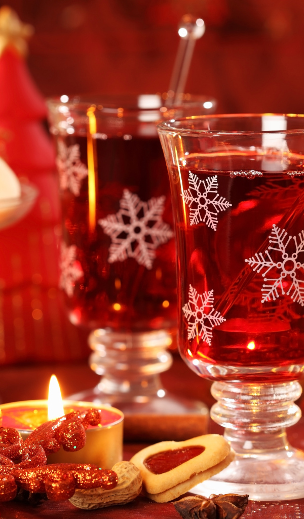 Два стакана горячего глинтвейна на столе с печеньем на Новый год 