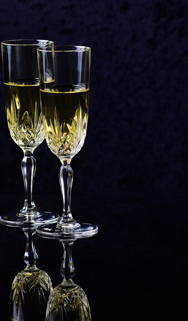 Два бокала с шампанский на черном фоне