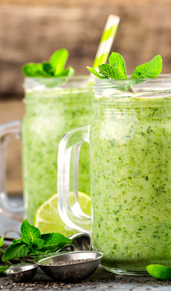 Два зеленых смузи на столе с киви, мятой и зеленым яблоком