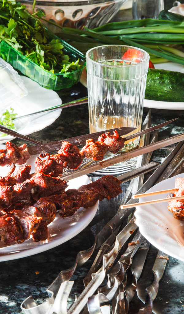 Аппетитный шашлык на шампурах на столе 