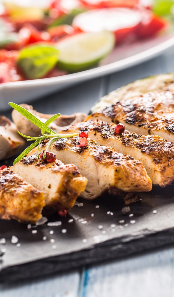 Запеченное куриное мясо на доске с помидорами 