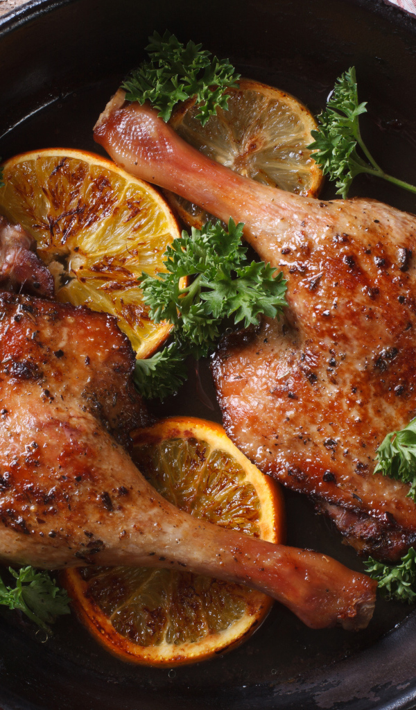 Куриные окорочка в сковороде с кольцами апельсина и петрушкой
