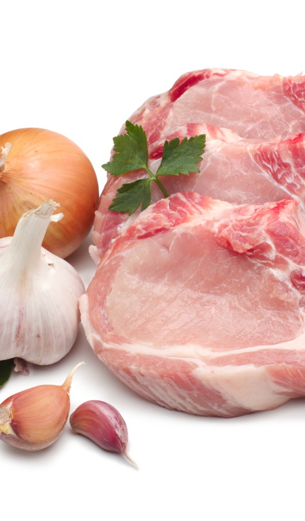Куски мяса на белом фоне с луком и чесноком