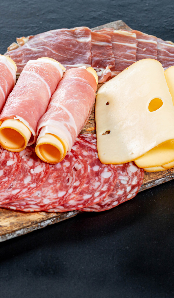 Ветчина на доске с колбасой и твердым сыром