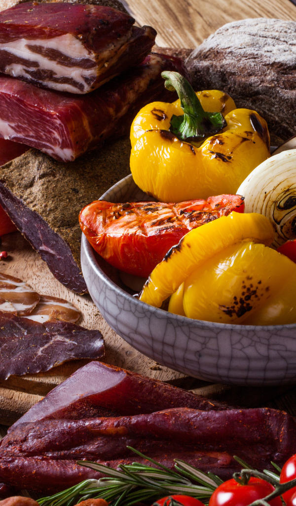 Мясные продукты на столе с запеченными овощами