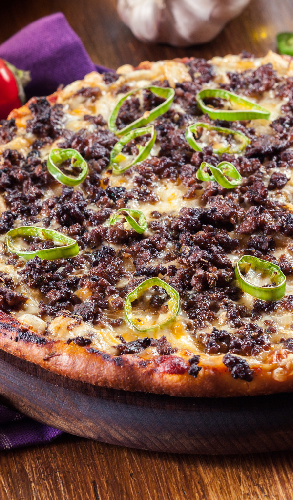 Пицца на доске с мясом и перцем 