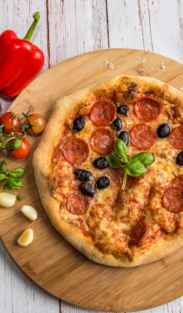 Пицца на доске с овощами и солью 