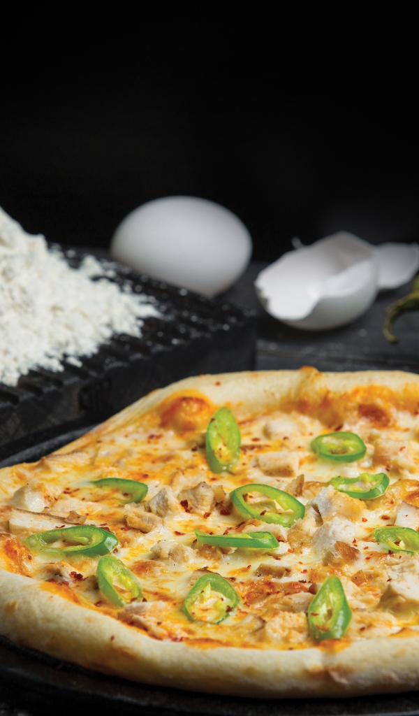 Пицца на столе с яйцами и перцем