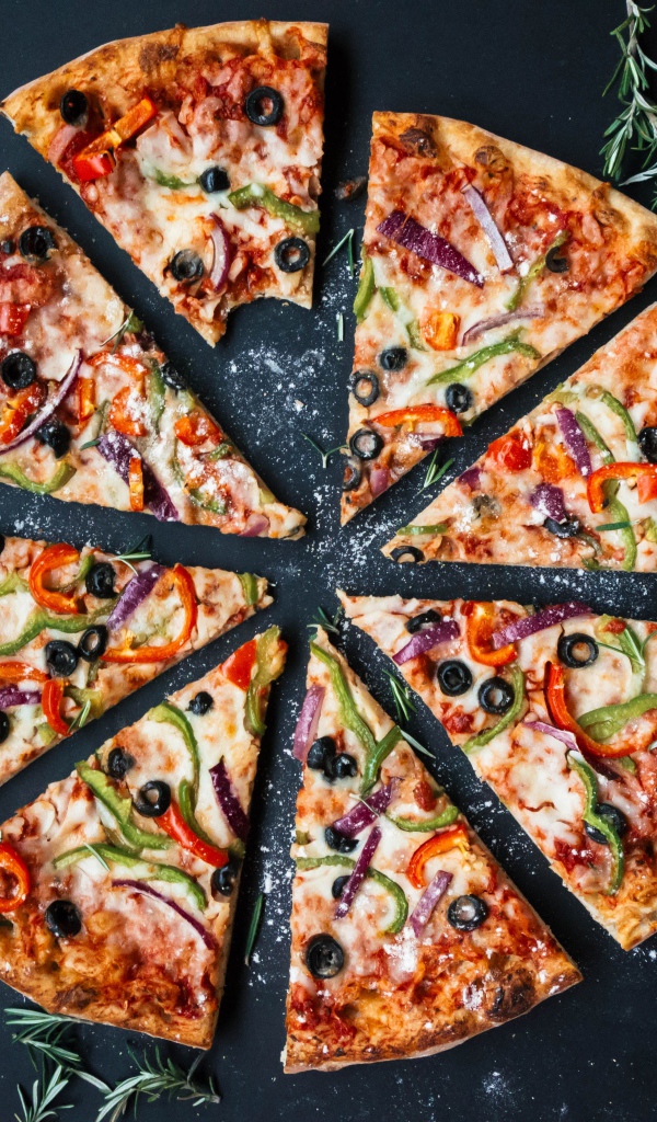 Пицца нарезанна на куски на сером столе