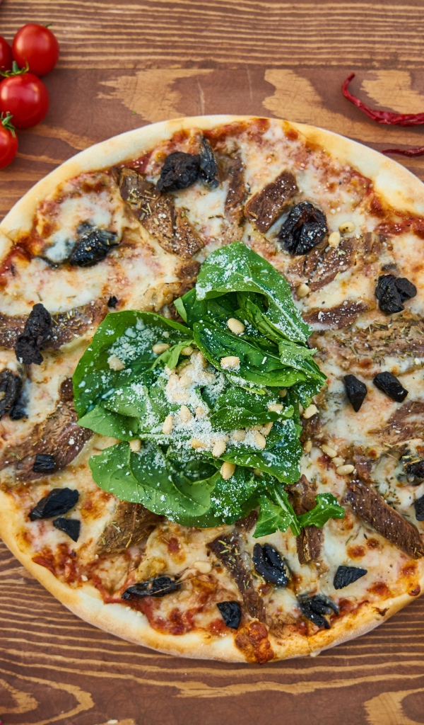 Пицца с мясом и шпинатом на столе 