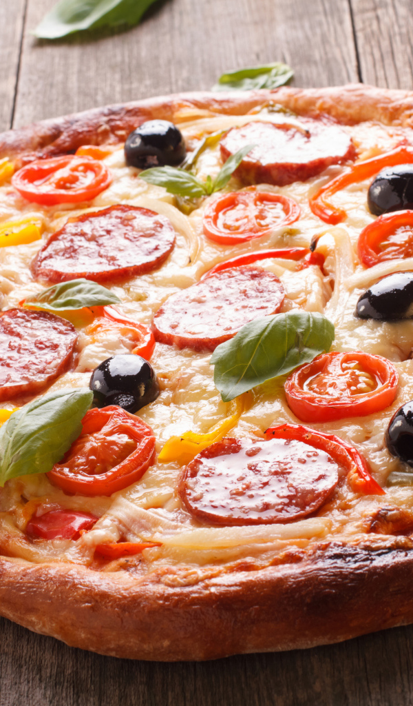 Румяная пицца с колбасой, помидорами, оливками и сыром