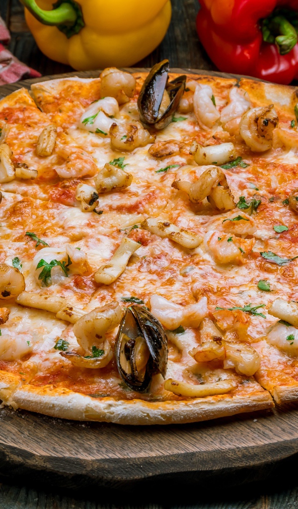 Вкусная пицца с морепродуктами на деревянной доске