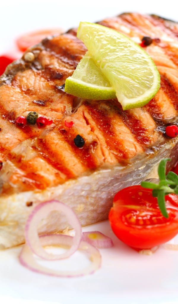 Кусок жареной рыбы с овощами на белом фоне 