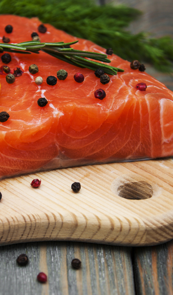 Кусок красной рыбы с лимоном и черным перцем