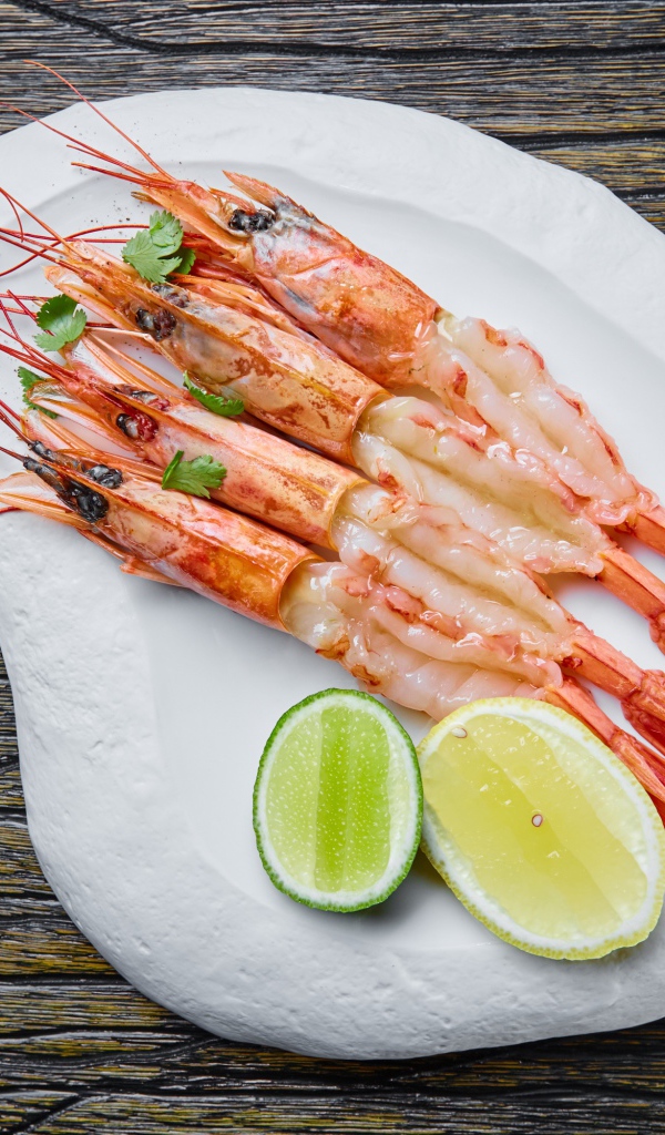Appetizing prawns on a white plate with lemon