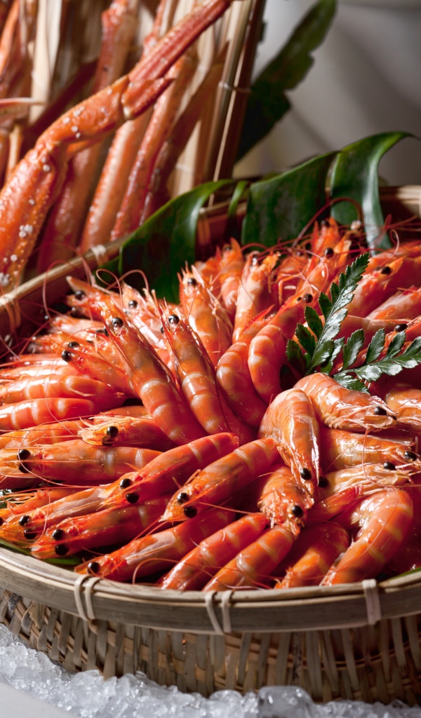 Вареные креветки лежат в корзине на столе крабами