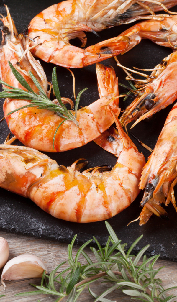 Вареные креветки на столе с лимонами и помидорами