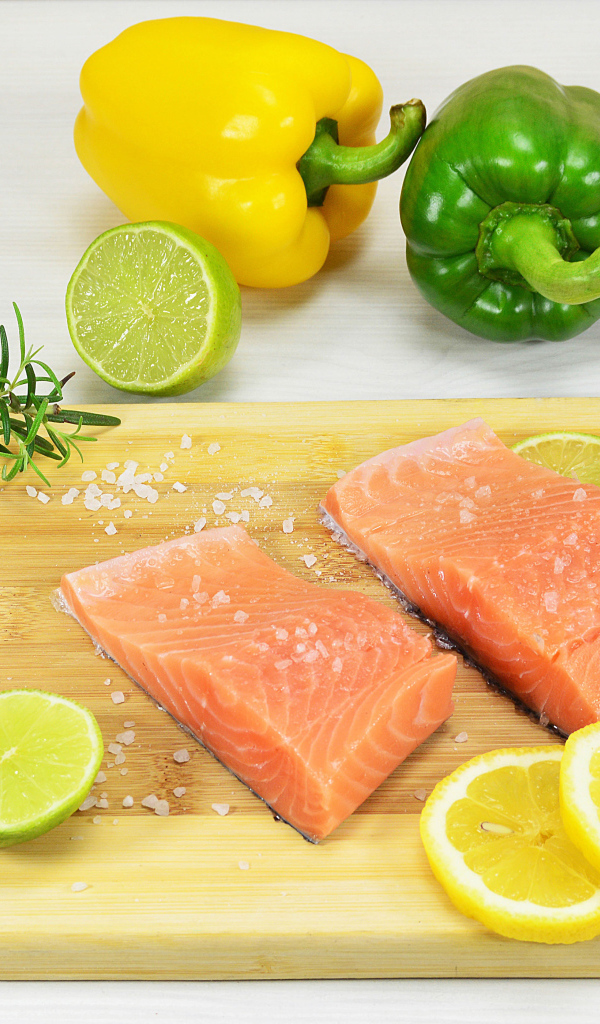 Красная рыба на разделочной доске с лимоном и перцем 