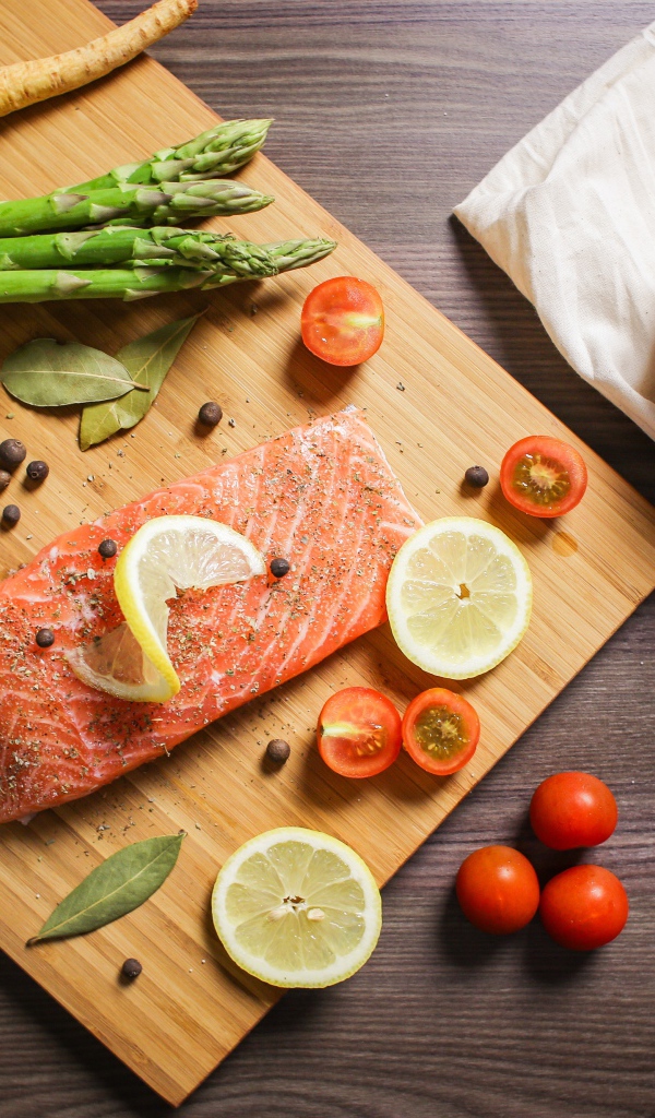 Красная рыба на столе со специями и овощами