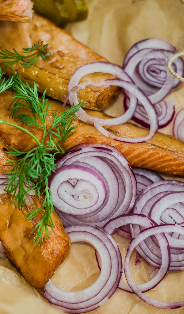 Копченое филе рыбы на бумаге с луком