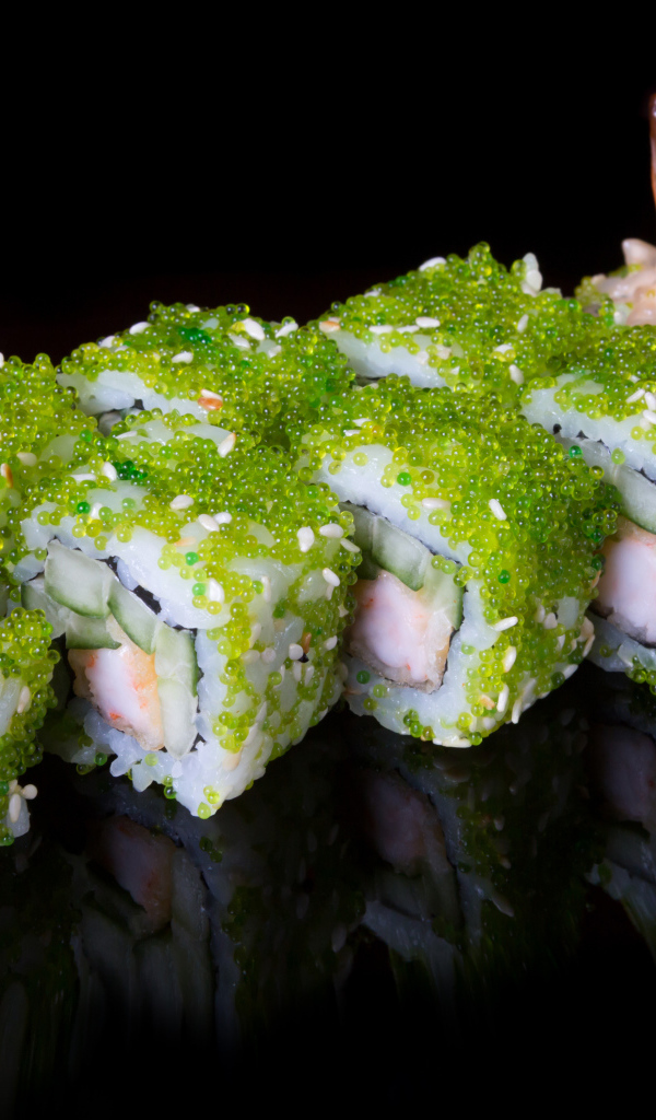 Суши с икрой и креветками на черном фоне