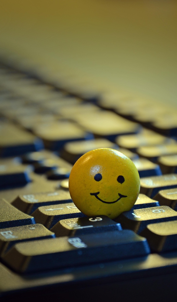 Желтый смайлик на черной клавиатуре 