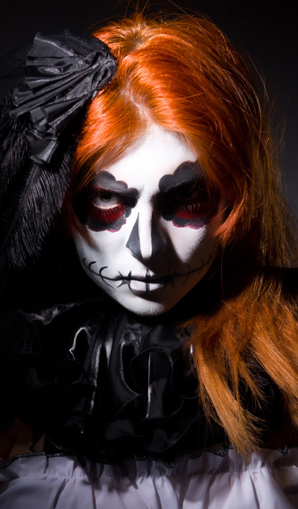 Рыжеволосая девушка с маской на лице на Хэллоуин 